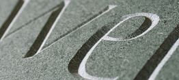 close up of incised lettering on green slate